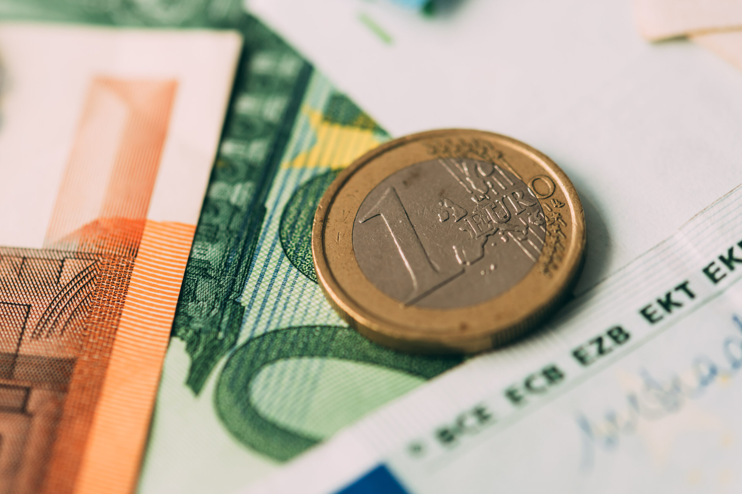 Euro coins on cash stack closeup